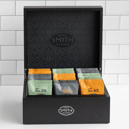Black tea box with assorted tea bags on a white background