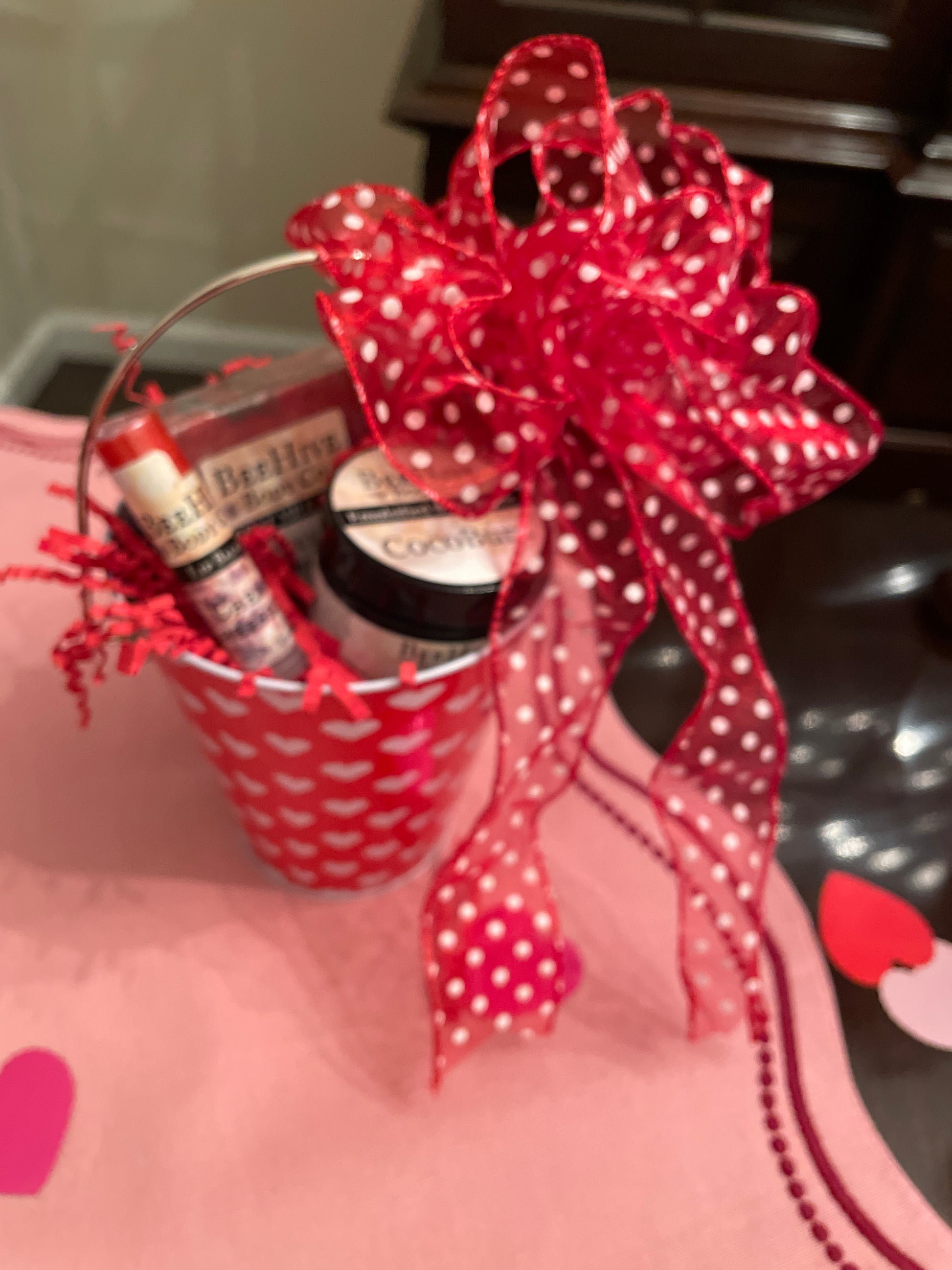 Decorative gift with red polka dot bow and pink heart design on a blurred background