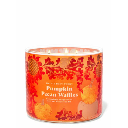 Bath & Body Works Pumpkin Pecan Waffles candle with decorative design on an orange background
