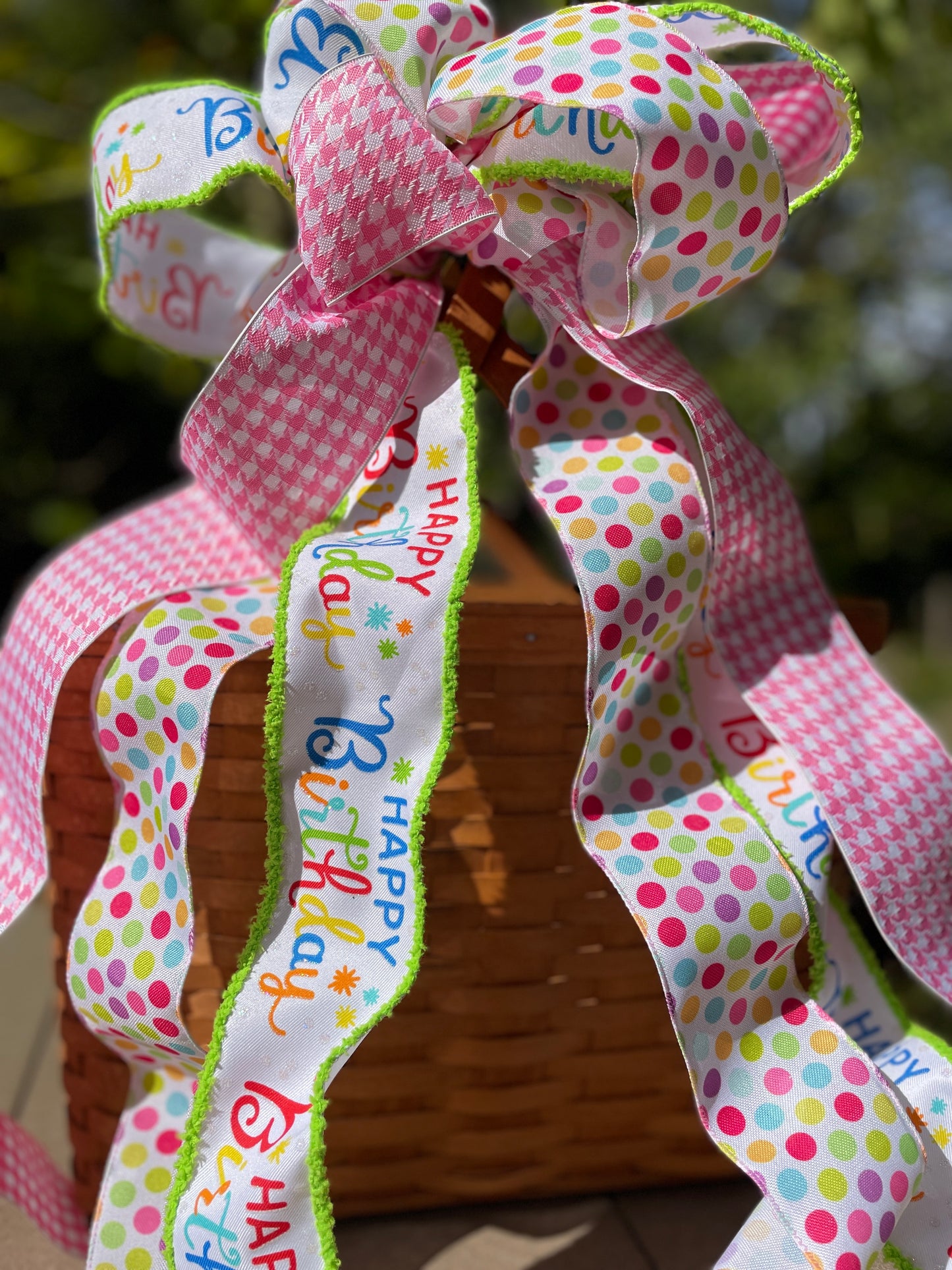 Colorful polka dot ribbon with 'Happy Birthday' text on a blurred background