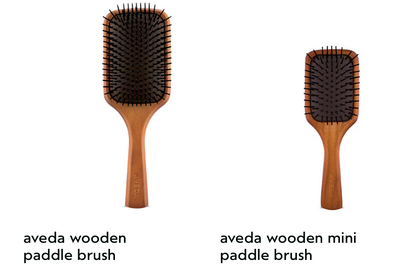 Two wooden paddle brushes from Aveda on a white background