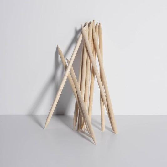 Bundle of natural wood cuticle sticks standing upright on a clean white background — dual-ended design for shaping and cleaning nails.
